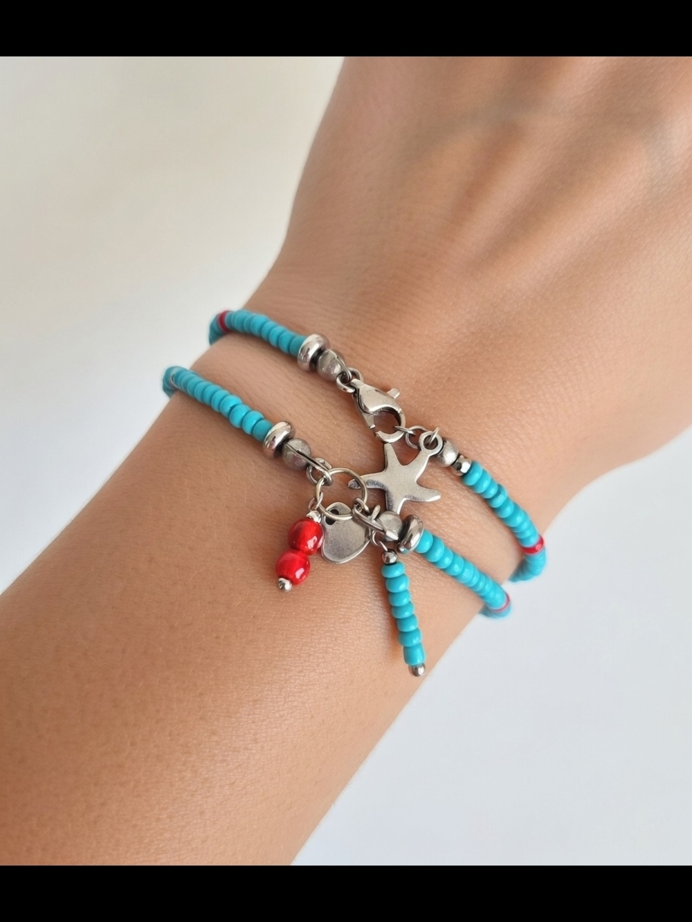 Two-strand bracelet with glass beads and stainless steel charms.